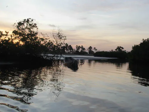 Pirogue dans le soleil couchant